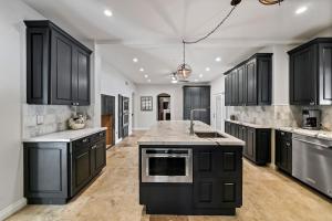 a large kitchen with black cabinets and appliances at California Oasis in Los Angeles