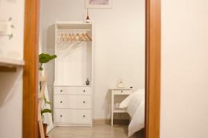 um quarto com uma cama e uma cómoda branca em La Casetta em Catânia