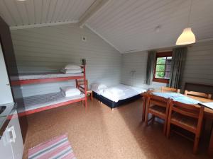 Habitación con 2 literas y mesa. en Lufta Camping & Restaurang, en Ånäset