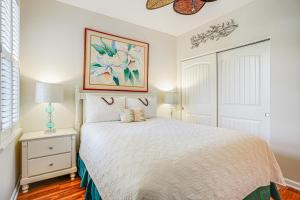 a bedroom with a white bed and a picture on the wall at Nihilani 32B in Princeville