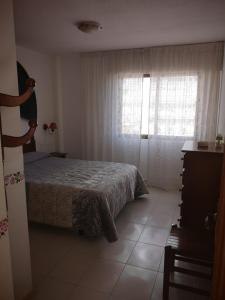 ein Schlafzimmer mit einem Bett und einem Fenster in der Unterkunft Playamar 231 in Alcossebre + 10 Fotos