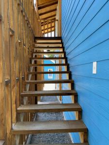 una escalera de madera que conduce a un edificio azul en Cabañas Mahuida, en Villarrica