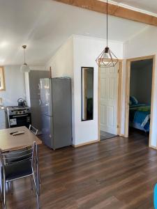 a kitchen with a table and a refrigerator in a room at Cabañas Mahuida in Villarrica