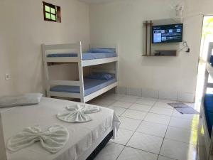 1 dormitorio con 1 cama y TV en una habitación en Residencial dos Ipês, en Itacaré