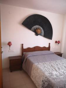 a bedroom with a bed with a fan on the wall at Playamar 231 in Alcossebre