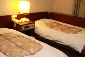 Postel nebo postele na pokoji v ubytování Hotel Los Inn Kochi