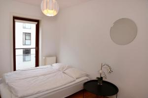 a white bedroom with a bed and a table at Scandi-Hygge 2 bedroom apartment in charming Christianshavn in Copenhagen