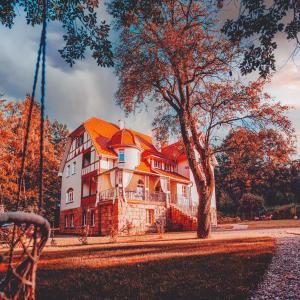 une grande maison avec un toit orange et un arbre dans l'établissement Sonnenblick, à Polanica-Zdrój
