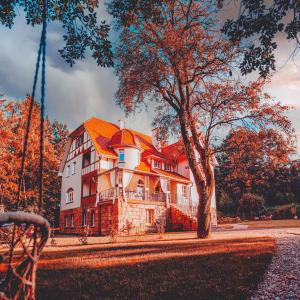 a large house with an orange roof and a tree at Sonnenblick in Polanica-Zdrój