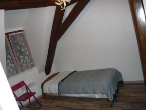 a bedroom with a bed and a red chair at La cour des meuniers - le Froment et l'Epeautre in Kaysersberg