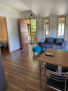 a living room with a blue couch and a table at Cabañas Mahuida in Villarrica