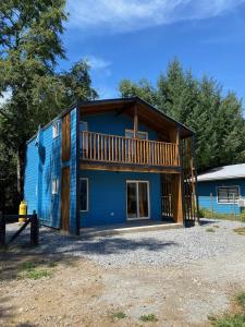 a large blue house with a balcony at Cabañas Mahuida in Villarrica