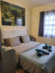 a bedroom with two beds and a painting on the wall at MaraVillas de Tenerife in Abades
