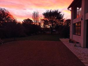 una puesta de sol detrás de una casa con una entrada de ladrillo en La douceur Saumuroise avec petit déjeuner, en Saumur