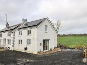 ein weißes Haus mit Sonnenkollektoren darüber in der Unterkunft Yemble Rose in Cardigan