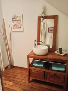 a bathroom with a sink and a mirror on a table at La douceur Saumuroise avec petit déjeuner in Saumur