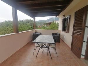 una sala da pranzo con tavolo e sedie sul balcone di Appartamenti Villa Rosa a Cala Gonone