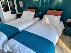 two beds sitting next to each other in a room at la chambre d hotes de marie indépendante et sa terrasse avec vue panoramique proche alpes mancelles in Sillé-le-Guillaume