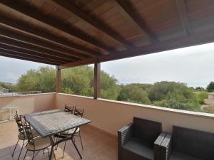 un patio con tavolo e sedie sul balcone. di Appartamenti Villa Rosa a Cala Gonone