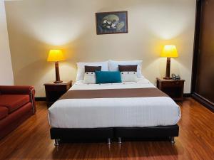 a bedroom with a large bed with two lamps at Hotel La Sabana in Bogotá