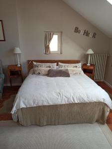 una camera da letto con un grande letto con lenzuola bianche di La douceur Saumuroise avec petit déjeuner a Saumur