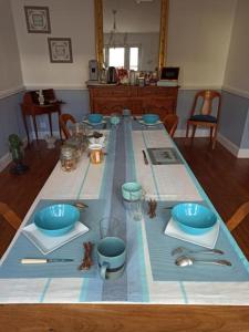 una mesa con tazones azules y utensilios en ella en La douceur Saumuroise avec petit déjeuner en Saumur