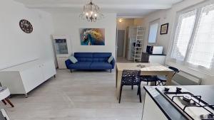 een woonkamer met een blauwe bank en een tafel bij Gîte « l’Escapade Cabassoise » in Cabasse