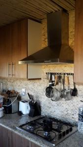 a kitchen with a stove and a stove top at Piedra De Agua Chacra, casa, piscina, bosque, río. in Minas