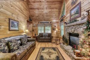 a living room with a stone fireplace in a log cabin at MYSTIC MOUNTAIN - GREAT LOCATION! CLOSE TO ALL THE ACTION! cabin in Pigeon Forge