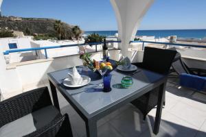 a table on a balcony with a view of the ocean at Pissouri Beach Apartments in Pissouri