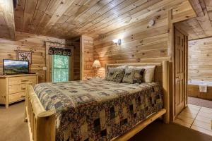 a bedroom with a bed in a log cabin at MYSTIC MOUNTAIN - GREAT LOCATION! CLOSE TO ALL THE ACTION! cabin in Pigeon Forge