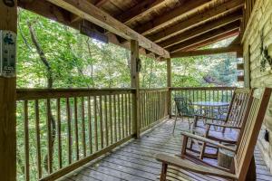 a porch with two chairs and a table on it at MYSTIC MOUNTAIN - GREAT LOCATION! CLOSE TO ALL THE ACTION! cabin in Pigeon Forge