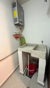 a bathroom with a sink and a red bucket at Apartamento Hospicio Cabañas in Guadalajara