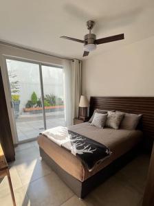 a bedroom with a bed and a ceiling fan at Apartamento Hospicio Cabañas in Guadalajara