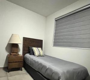 a bedroom with a bed and a lamp and a window at Apartamento Hospicio Cabañas in Guadalajara