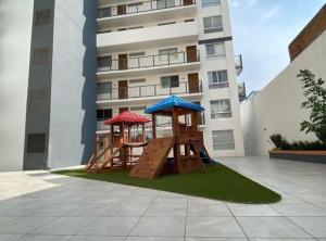 a playground in front of a tall building at Apartamento Hospicio Cabañas in Guadalajara