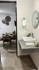 a bathroom with a sink and a table and a mirror at Apartamento Hospicio Cabañas in Guadalajara