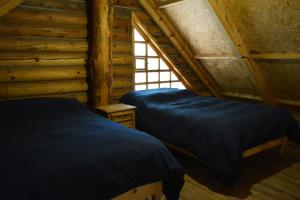 two beds in a log cabin with a window at Cómoda Cabaña de Descanso Parque La Pirámide in Las Adjuntas