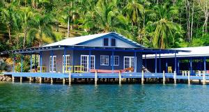 niebieski dom na przystani nad wodą w obiekcie MISTY MOONLIGHT VILLAS w mieście Bocas del Toro