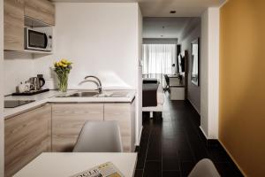 a small kitchen with a sink and a counter at be.HOTEL in St. Julianʼs