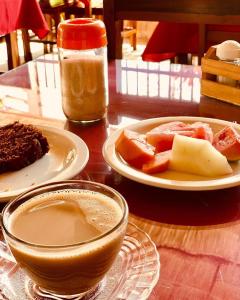 una mesa con platos de comida y una taza de café en Okay Pousada praia de iracema, en Fortaleza