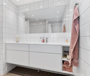 a bathroom with white cabinets and a large mirror at Scandi-Hygge 2 bedroom apartment in charming Christianshavn in Copenhagen