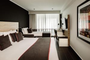 a hotel room with two beds and a television at be.HOTEL in St. Julianʼs