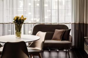 a living room with a couch and a table with a vase of flowers at be.HOTEL in St. Julianʼs