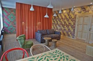un salon avec un canapé, une table et des chaises dans l'établissement Kolorowy apartament A9 Katowice Nikiszowiec, à Katowice
