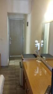 a bathroom with a large mirror and a door at Nafsika Hotel in Rhodes Town