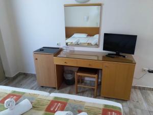 einen Schreibtisch mit einem Computer und einem Spiegel im Zimmer in der Unterkunft Nafsika Hotel in Rhodos (Stadt)