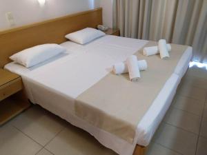 a large white bed with two rolled towels on it at Nafsika Hotel in Rhodes Town
