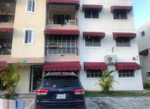 a car parked in front of a building with red awnings at Hermoso Apartamento ideal familia in Pantoja