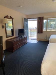 a hotel room with a bed and a mirror and a television at AmeriCoast Inn in Brookings